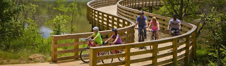 Image of five people cycling across a wooden bridge